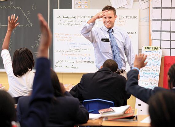 Teacher directing students from the front of a classroom